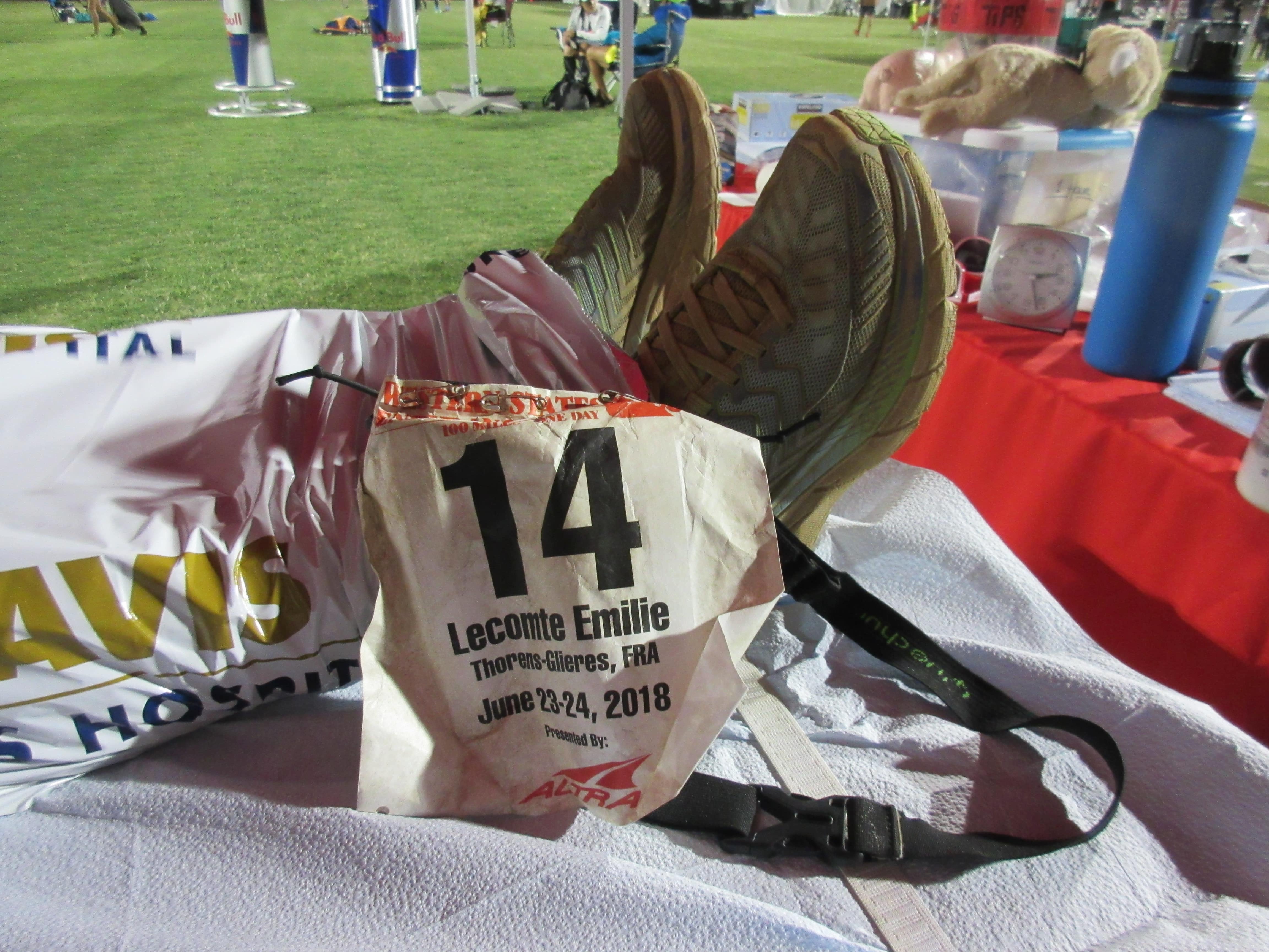 A crumpled bib in front of running shoes, the runner is laying down out of shot, at Western States 100