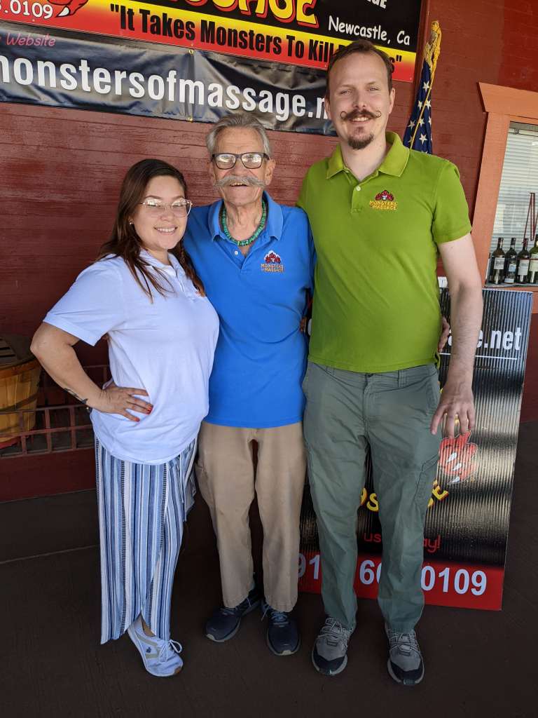 A woman wearing a white shirt, a man with a grey moustache in a blue shirt, and a tall man in a lime shirt in Auburn, CA